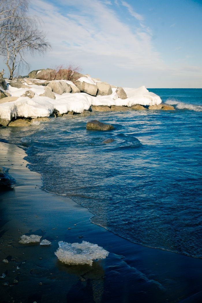 service-02 A serene winter scene of a snow-covered beach and icy waters in Toronto, Canada.