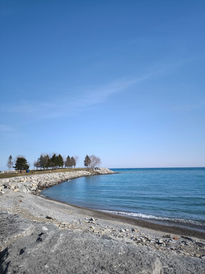 service-06 Tranquil beach scenery in Toronto with blue skies and calm waters.